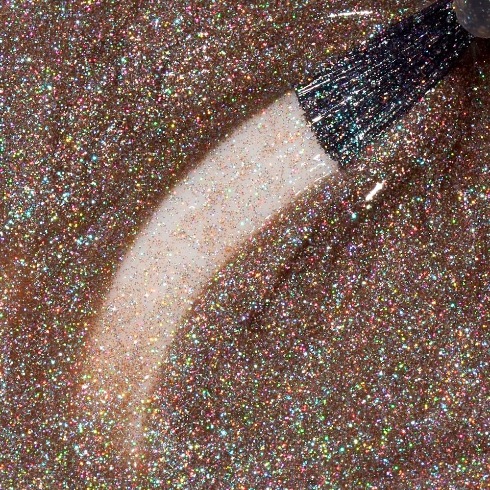 Nahaufnahme eines roségoldenen Glitzer-Nagellacks mit holografischem Schimmer und Pinsel auf der Lackoberfläche