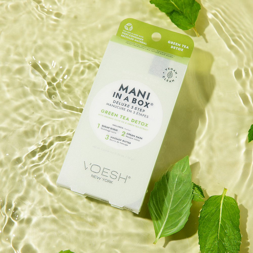 VOESH Mani in a Box Green Tea Detox, Deluxe 3-Step Maniküre-Set in Verpackung auf Wasseroberfläche mit grünen Blättern