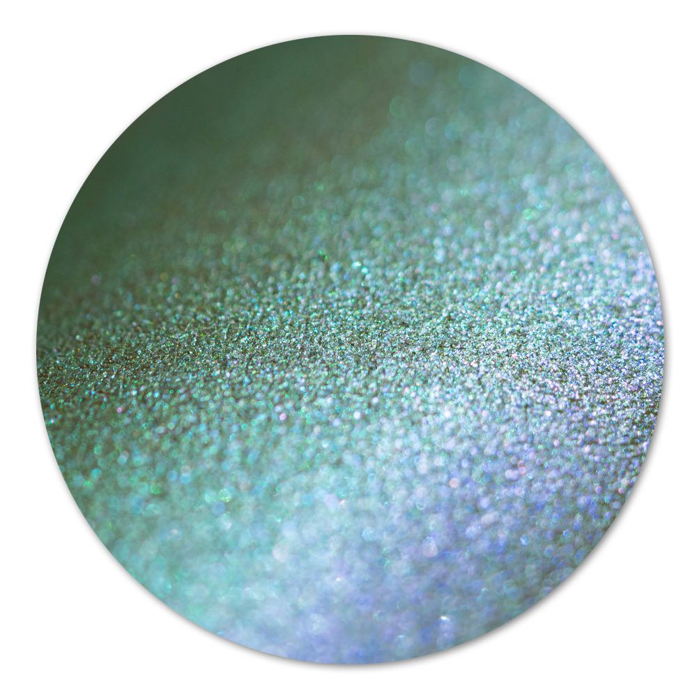 Nahaufnahme einer glitzernden, grünen Oberfläche mit schimmernden Partikeln