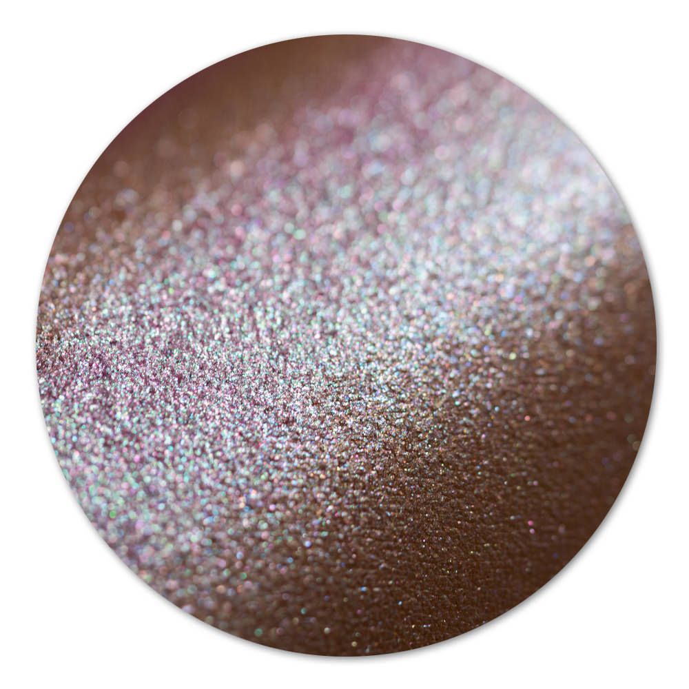 Detailaufnahme eines glitzernden Puders mit schimmernden Farben auf braunem Hintergrund