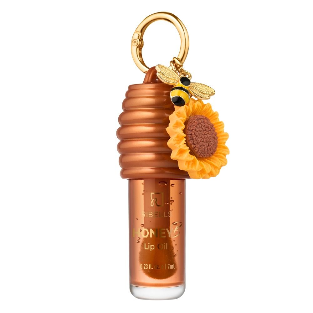 Ribells Honey Lip Oil in transparentem Flakon mit braunem Bienenstock-Deckel, goldenem Schlüsselring, Bienen- und Sonnenblumen-Anhänger