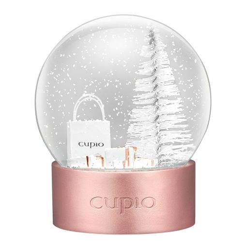 Schneekugel mit einem weißen Weihnachtsbaum, Geschenken und einer Cupio-Tasche.