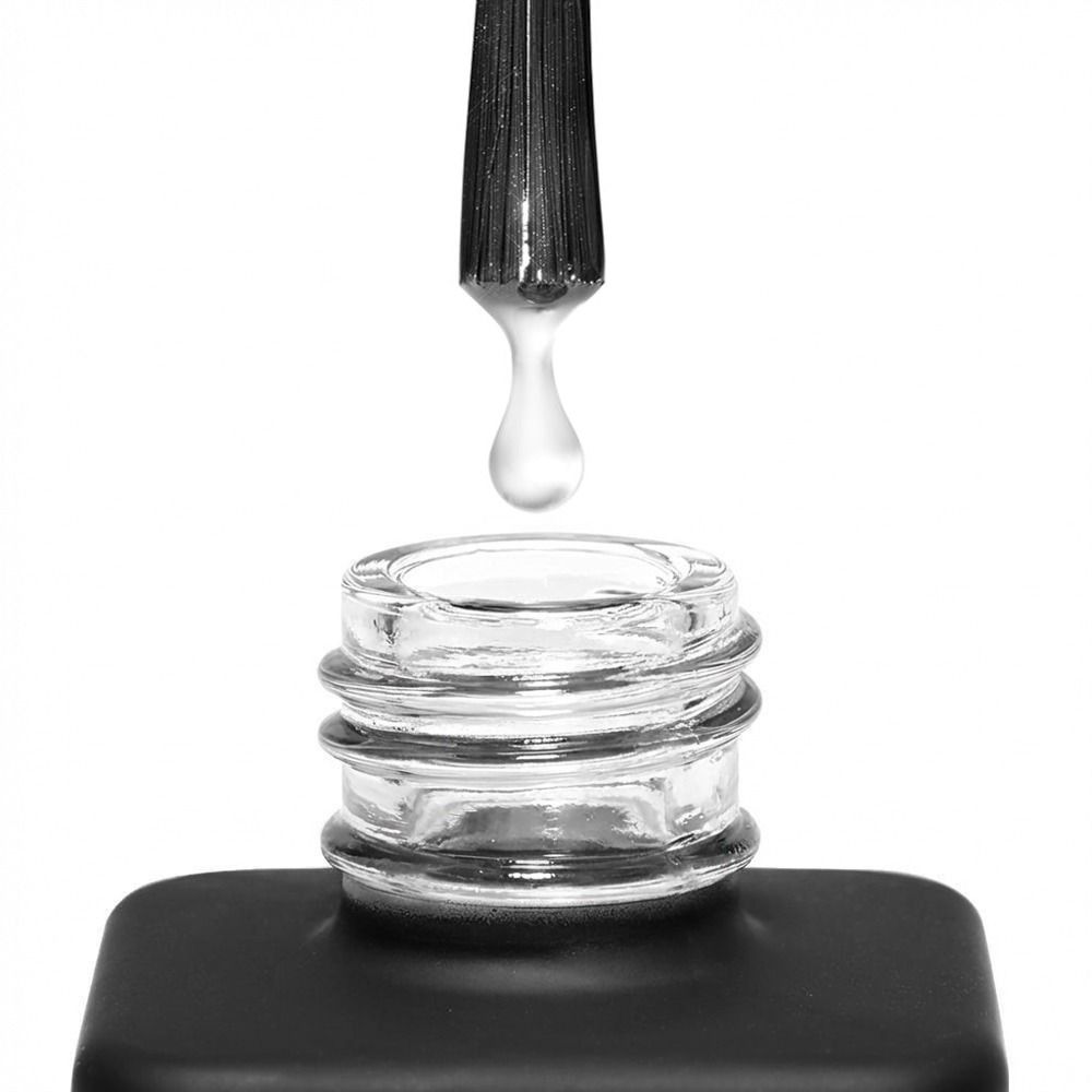 Detailbild einer geöffneten Nagellackflasche mit Pinsel und klarem Lacktropfen über der Glasöffnung