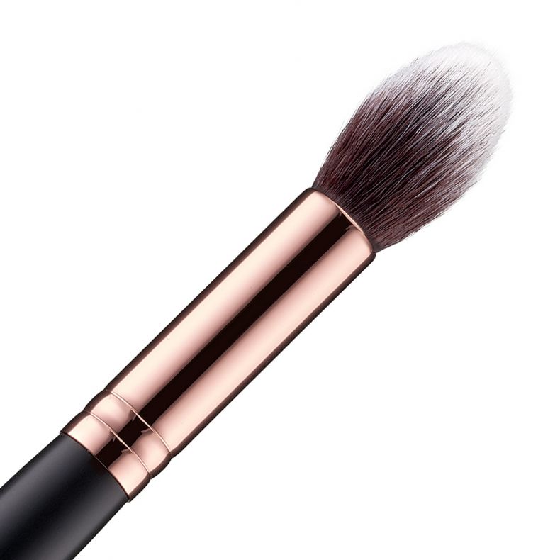 Detailaufnahme eines Make-up-Pinsels mit roségoldenem Griff und weichen Borsten