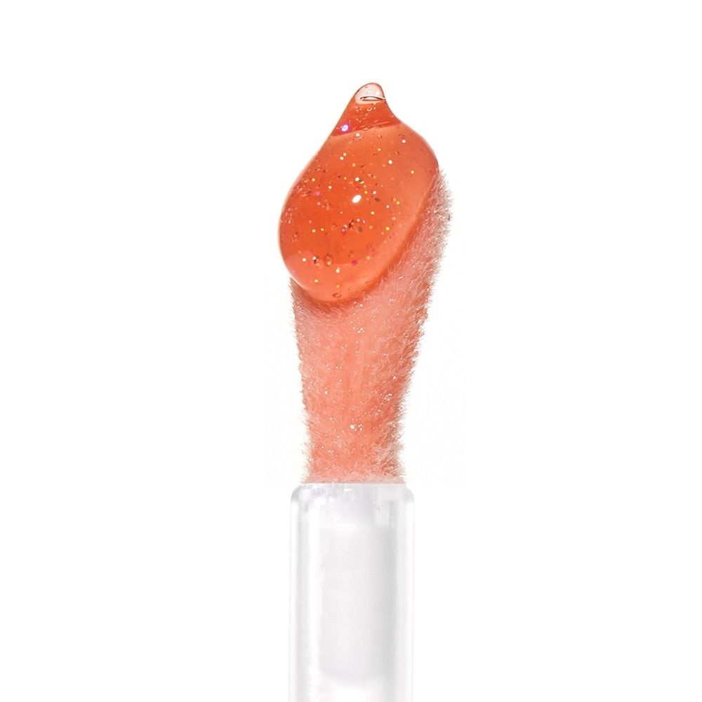 Nahaufnahme eines Applikators mit glitzerndem Lippenpflegeprodukt in Orange.