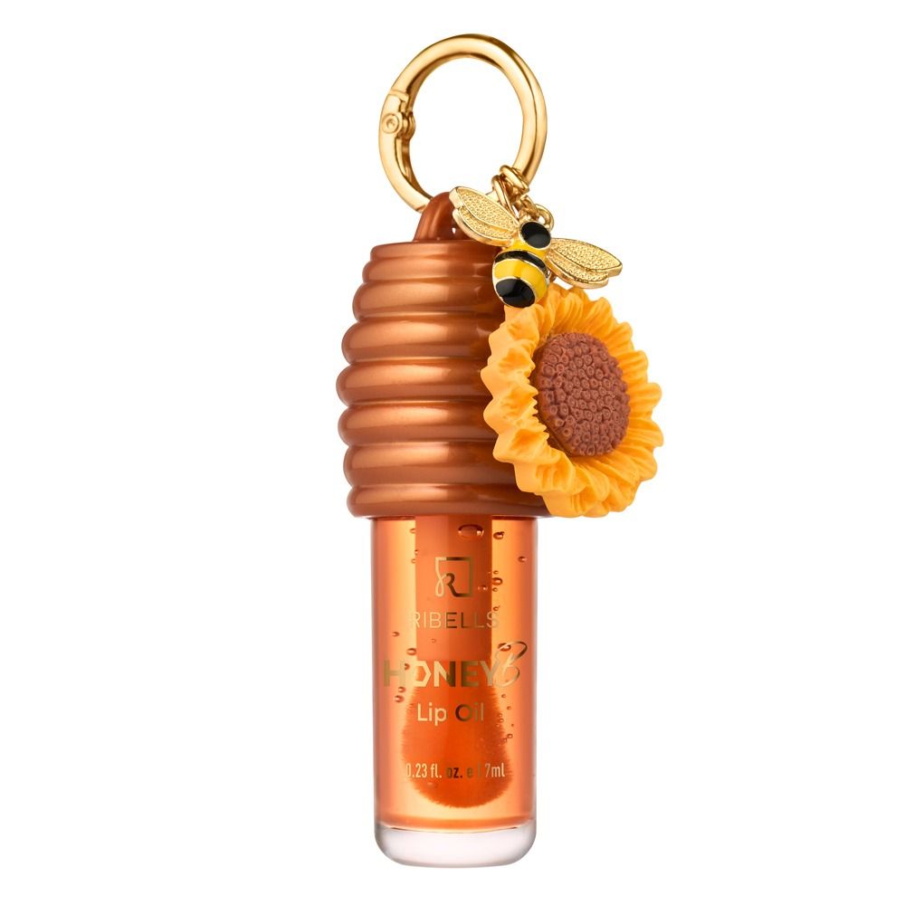 Ribellis Honey Lip Oil in goldenem Orangeton mit Bienenstock-Kappe, Schlüsselring, Bienenanhänger und Sonnenblume