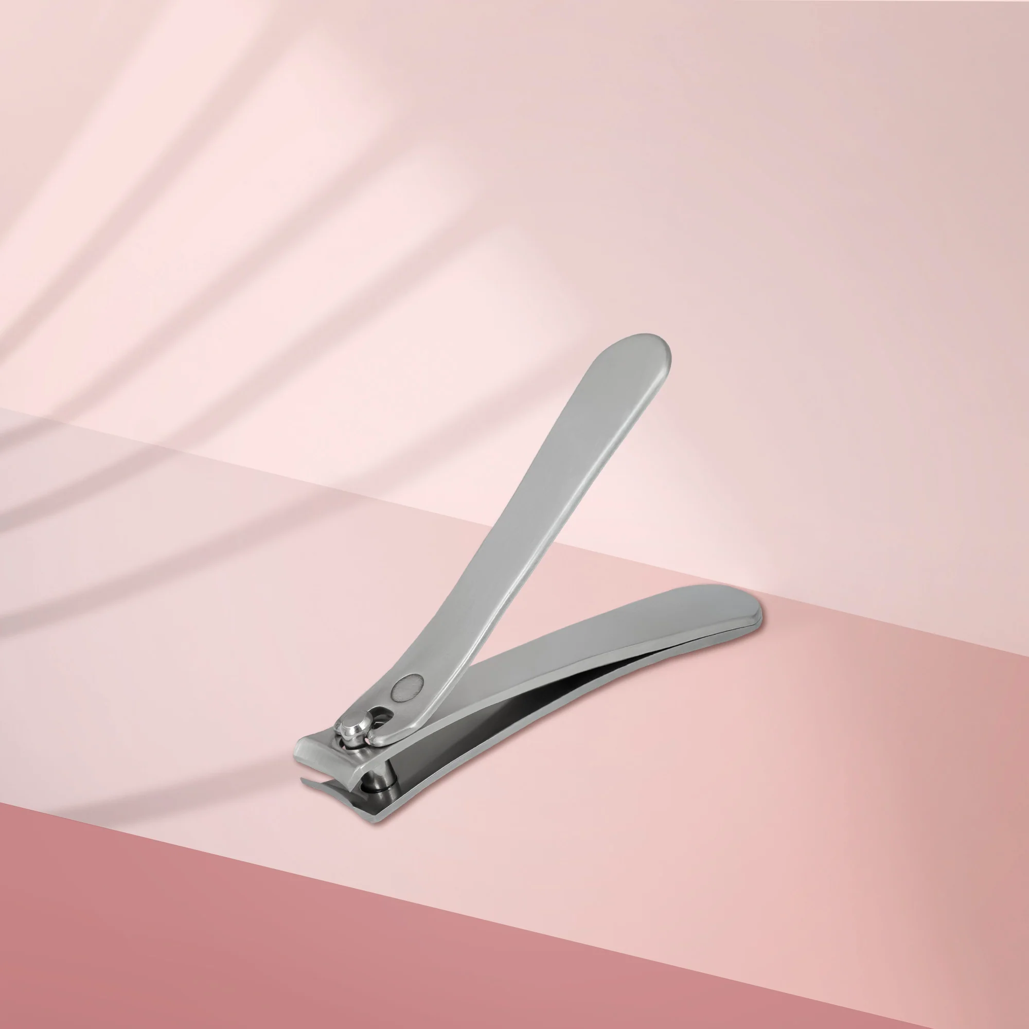 Edelstahl-Nagelknipser auf pastel-farbigem Hintergrund