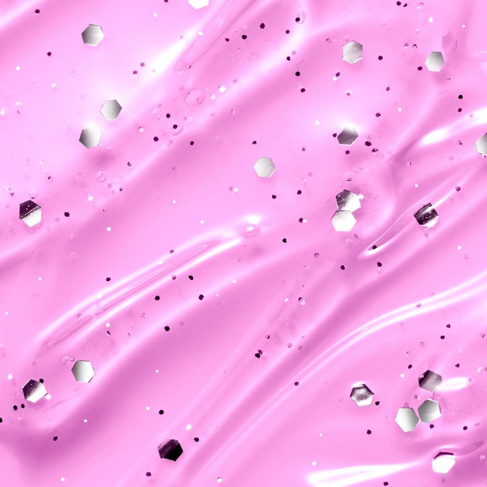 Nahaufnahme von pinkem Gel mit glänzenden hexagonalen und runden Glitzerpartikeln