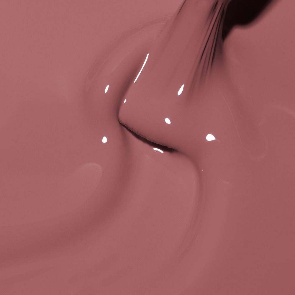 Makroaufnahme eines Pinsels in roséfarbenem Nagellack mit cremiger, glänzender Textur