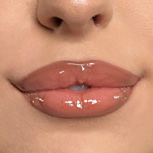 Nahaufnahme von Lippen mit glänzendem Nude-Rosé-Lipgloss