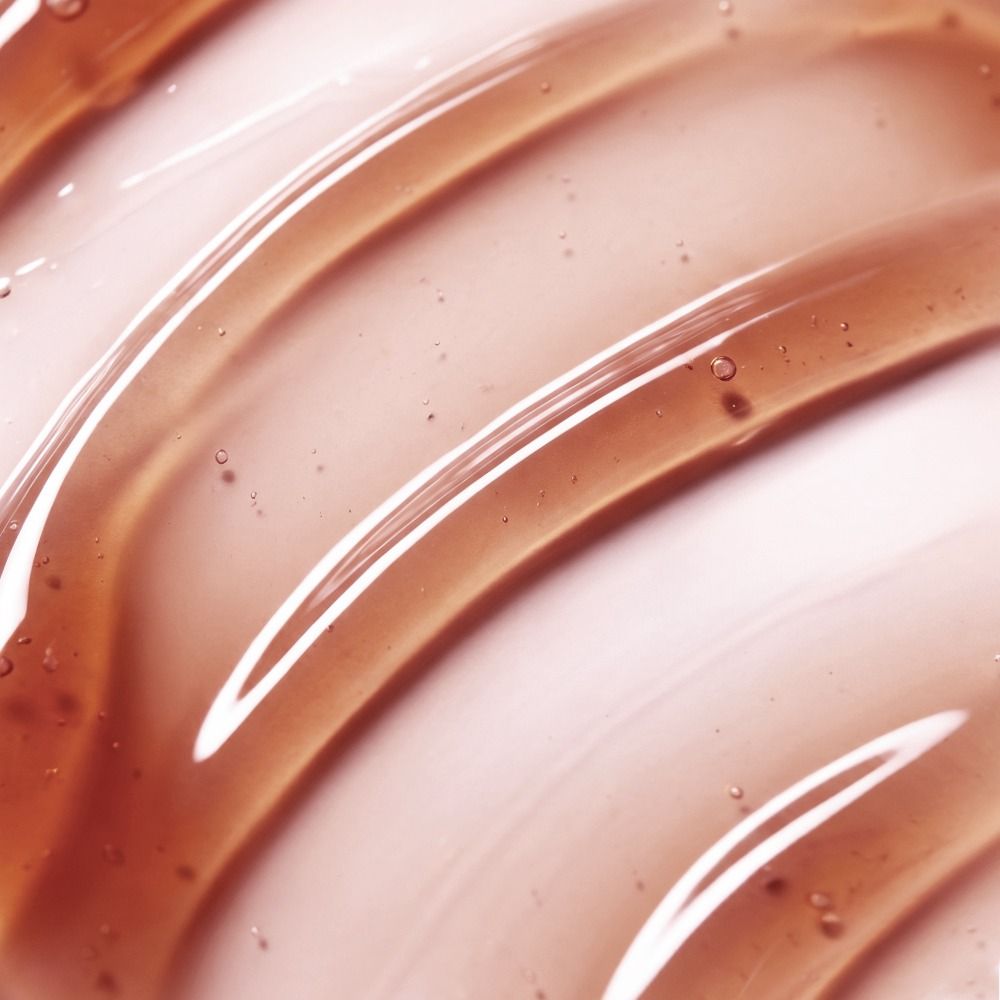 Makroaufnahme einer transparenten, bernsteinfarbenen Serum- oder Gel-Textur als Produktbild für Hautpflege oder Kosmetik