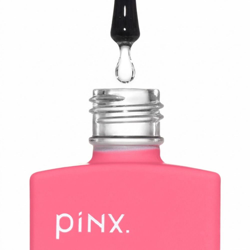 Nahaufnahme einer pinken PINX. Nagelöl-Flasche mit geöffneter Glasöffnung und Pipette mit klarem Tropfen darüber