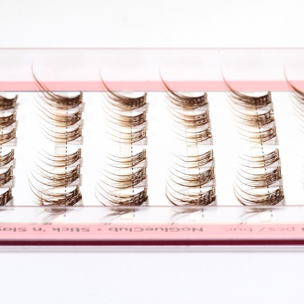 Nahaufnahme einer Wimpernbox mit braunen Einzelwimpern in verschiedenen Längen für Wimpernverlängerung und Lash-Styling